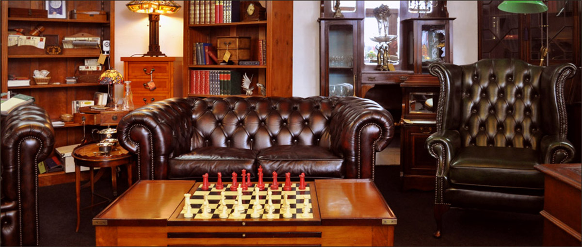 Chesterfield Sofa und Chesterfield Sessel, Bibliotheksregale und ein Game Table - So könnte Ihr Männerzimmer aussehen, wenn es einem klassischen Gentlemen's Club nachempfunden wurde.